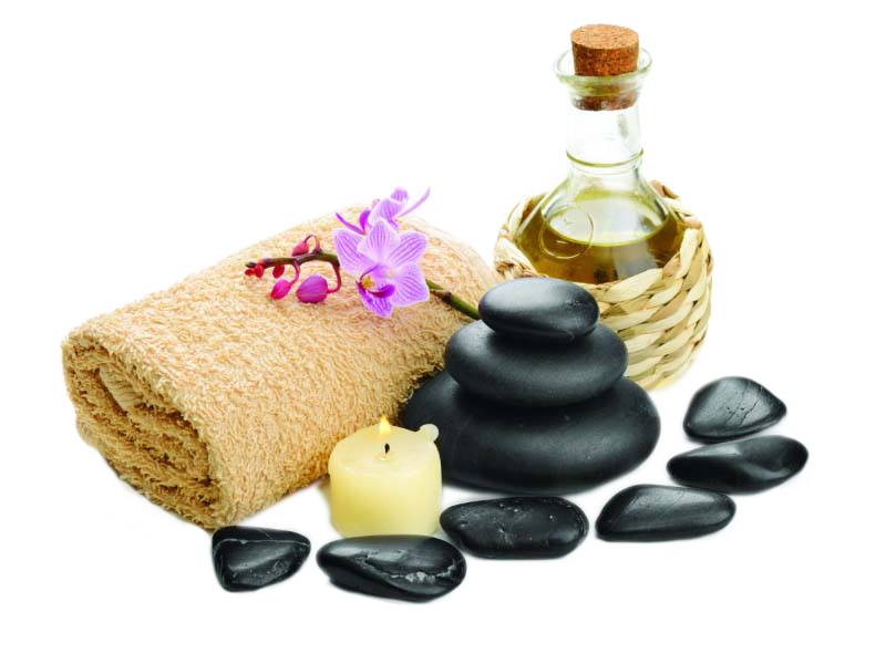 A towel , a bottle of oil , a candle , and black rocks on a white background.