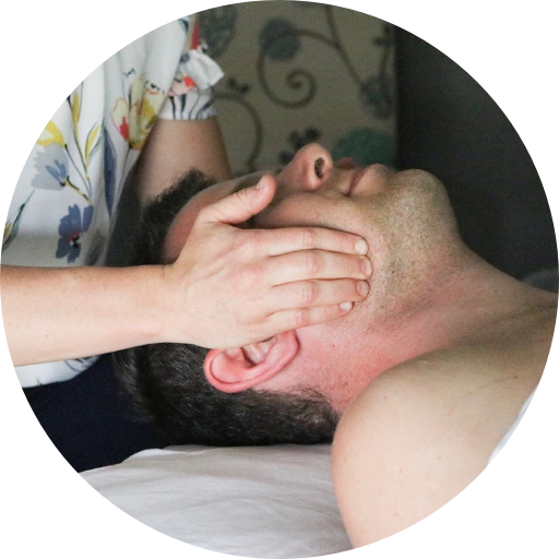 A man laying on a bed getting a massage from a woman