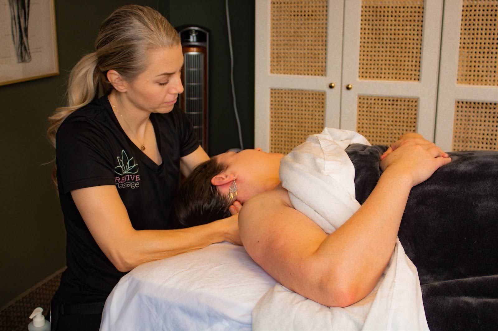 A woman is giving a man a massage on a massage table.