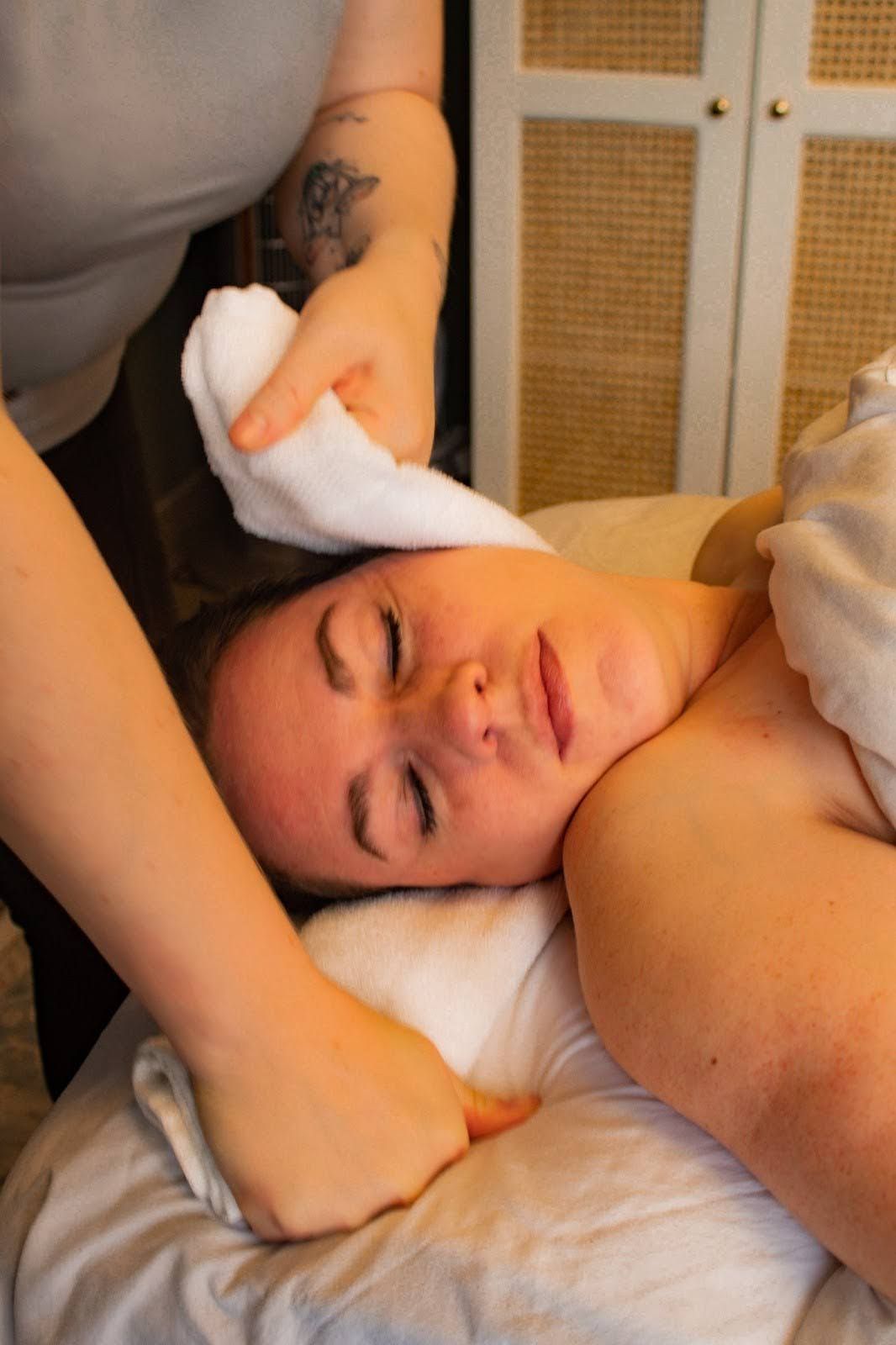 A woman is getting a massage with a towel on her face.