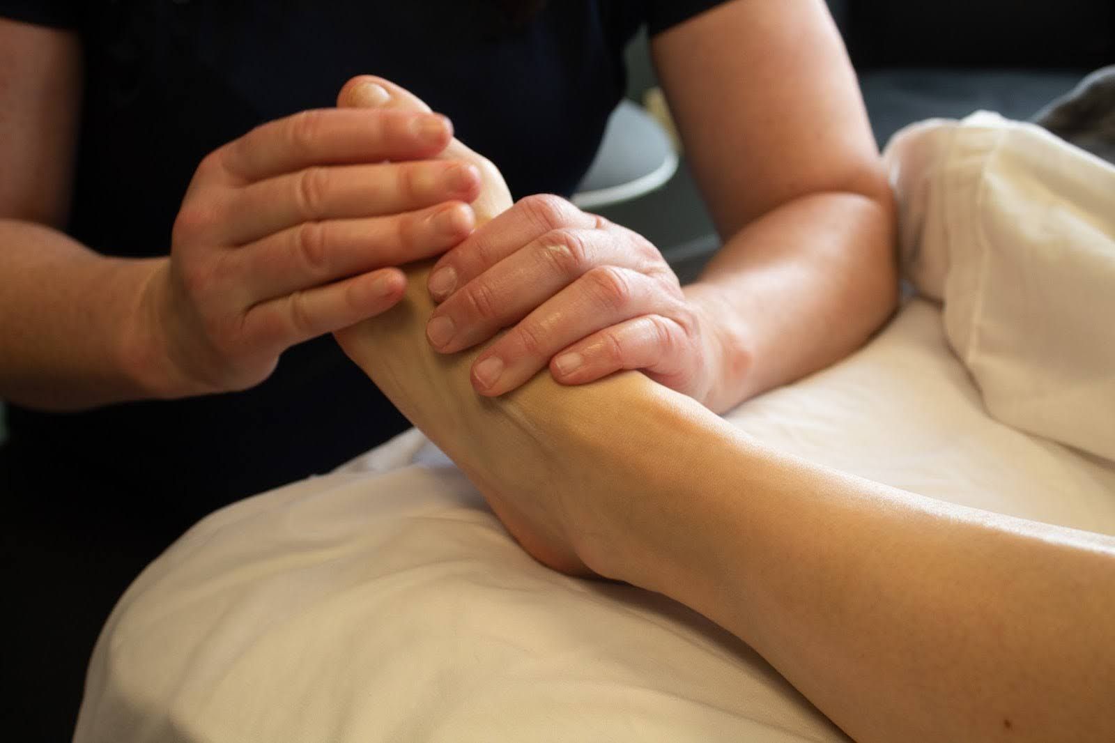 A person is giving a foot massage to another person.