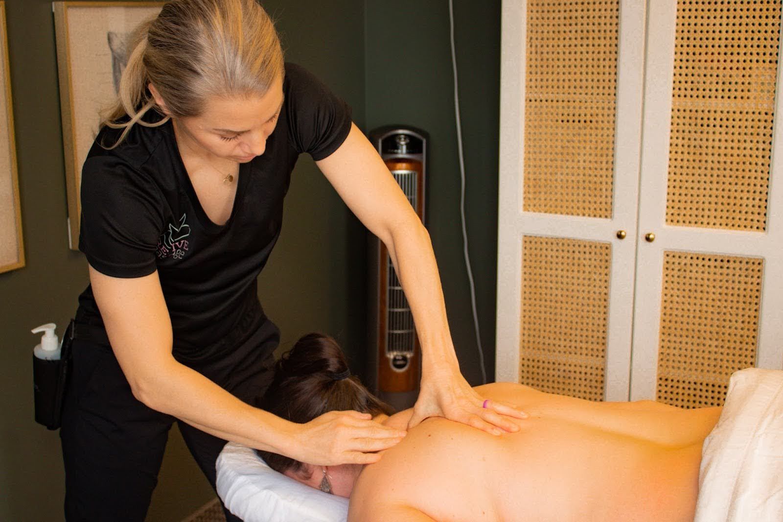 A woman is giving a man a massage in a spa.