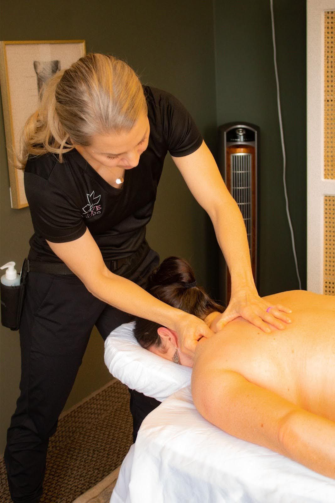 A woman is giving a man a massage on a table.