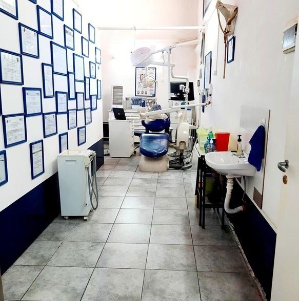 Un consultorio dental con una silla azul y un lavabo