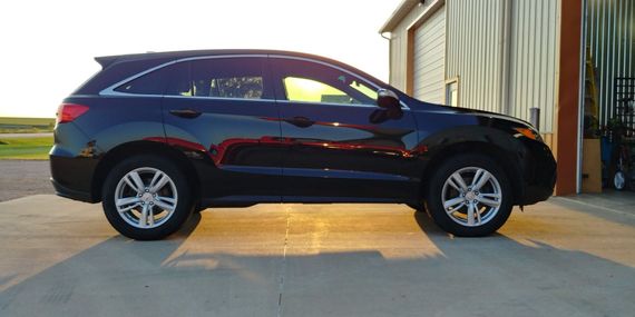 A black suv is parked in front of a garage.