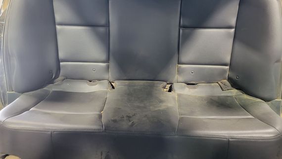 The back seat of a car is sitting on the ground.