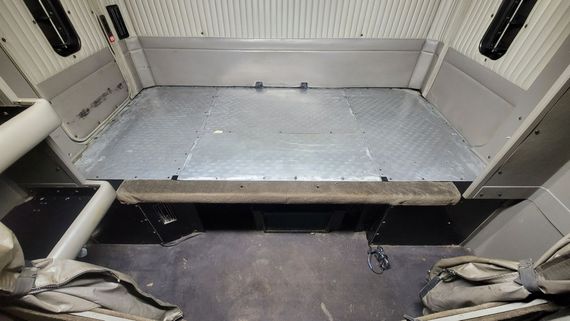 A room with a metal floor and a gray wall