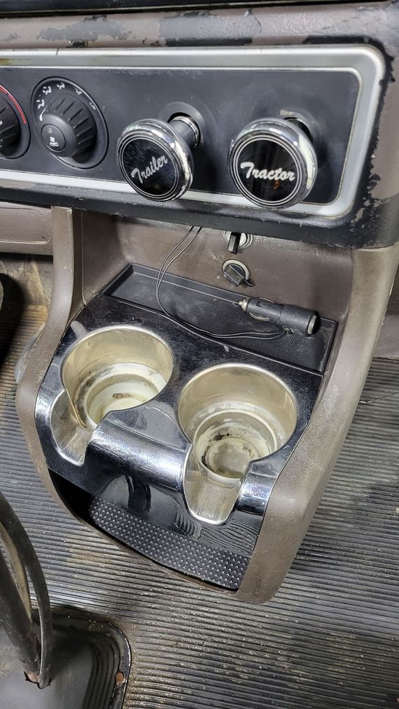 A close up of a cup holder on the dashboard of a car.