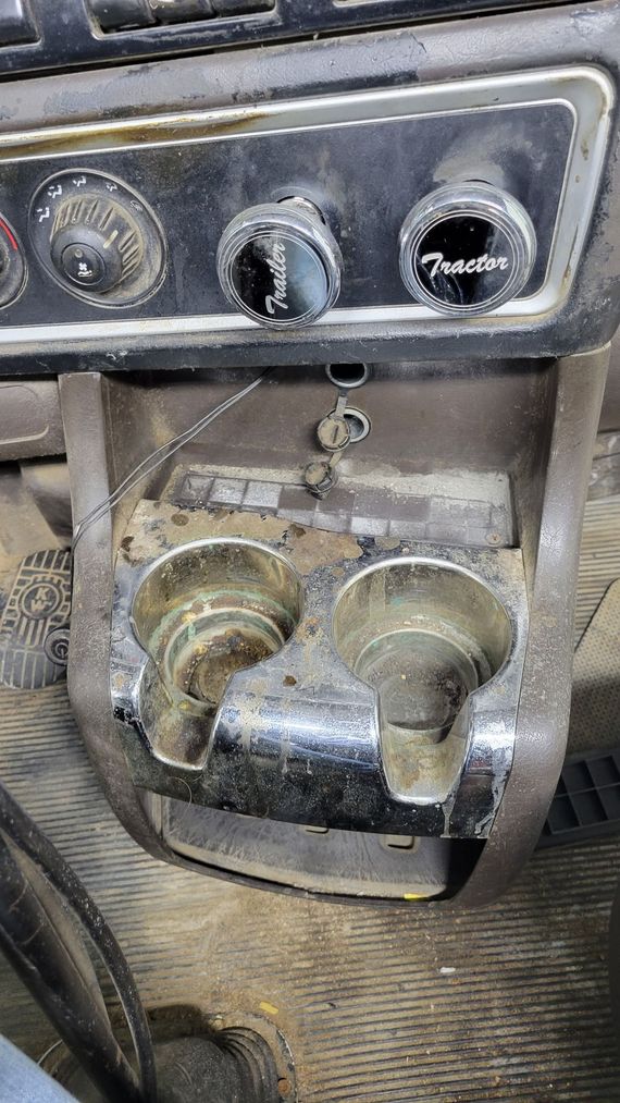 There is a cup holder on the dashboard of a car.