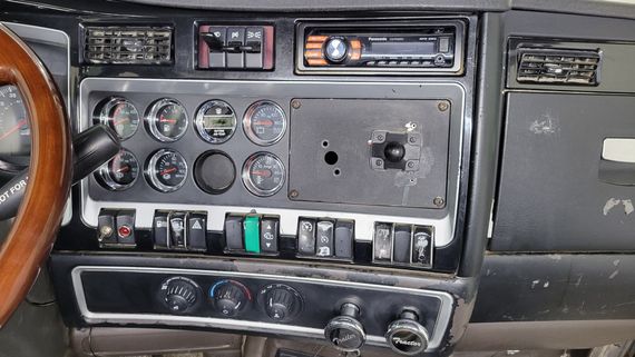 A dashboard of a car with a radio and a steering wheel