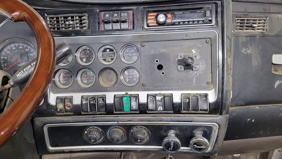 The dashboard of a car with a wooden steering wheel