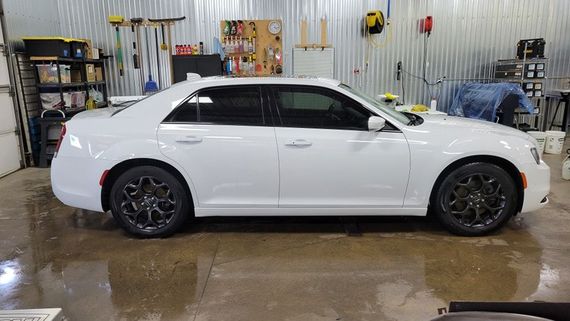 A white car is parked in a garage.