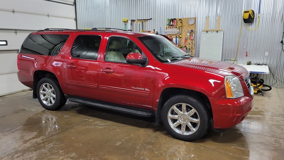 Red GMC Yukon SUV in a garage.