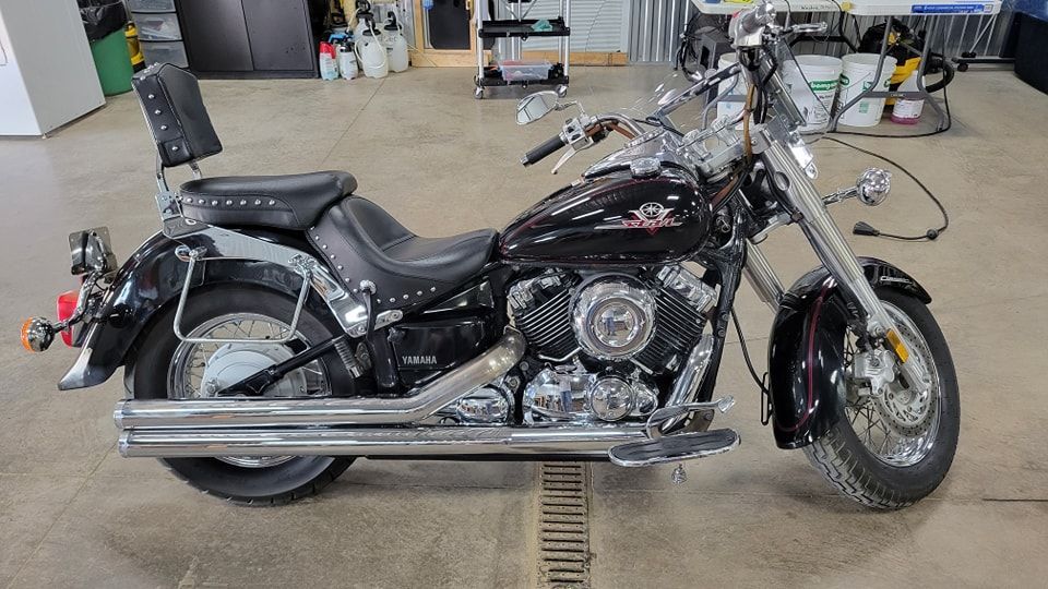 A black motorcycle is parked in a garage.