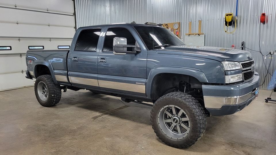 A gray pickup truck is parked in a garage.