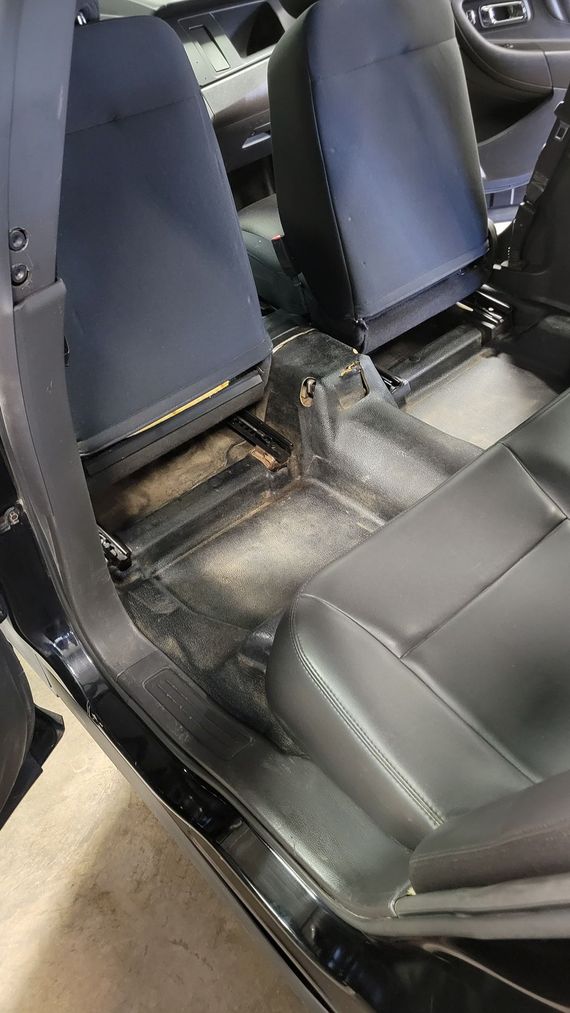 The inside of a car with the seats removed.