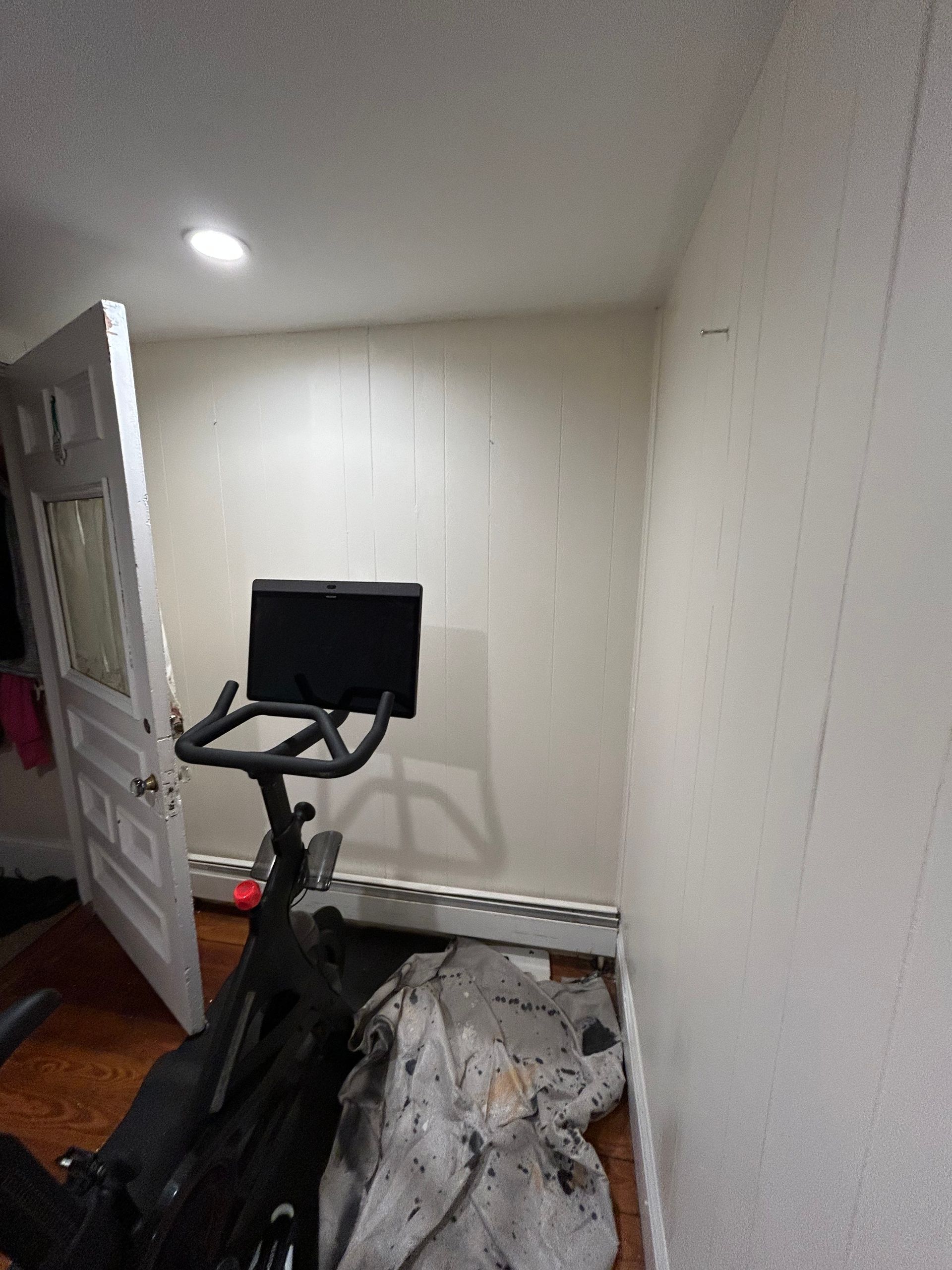 A bicycle is sitting in a room next to a door.