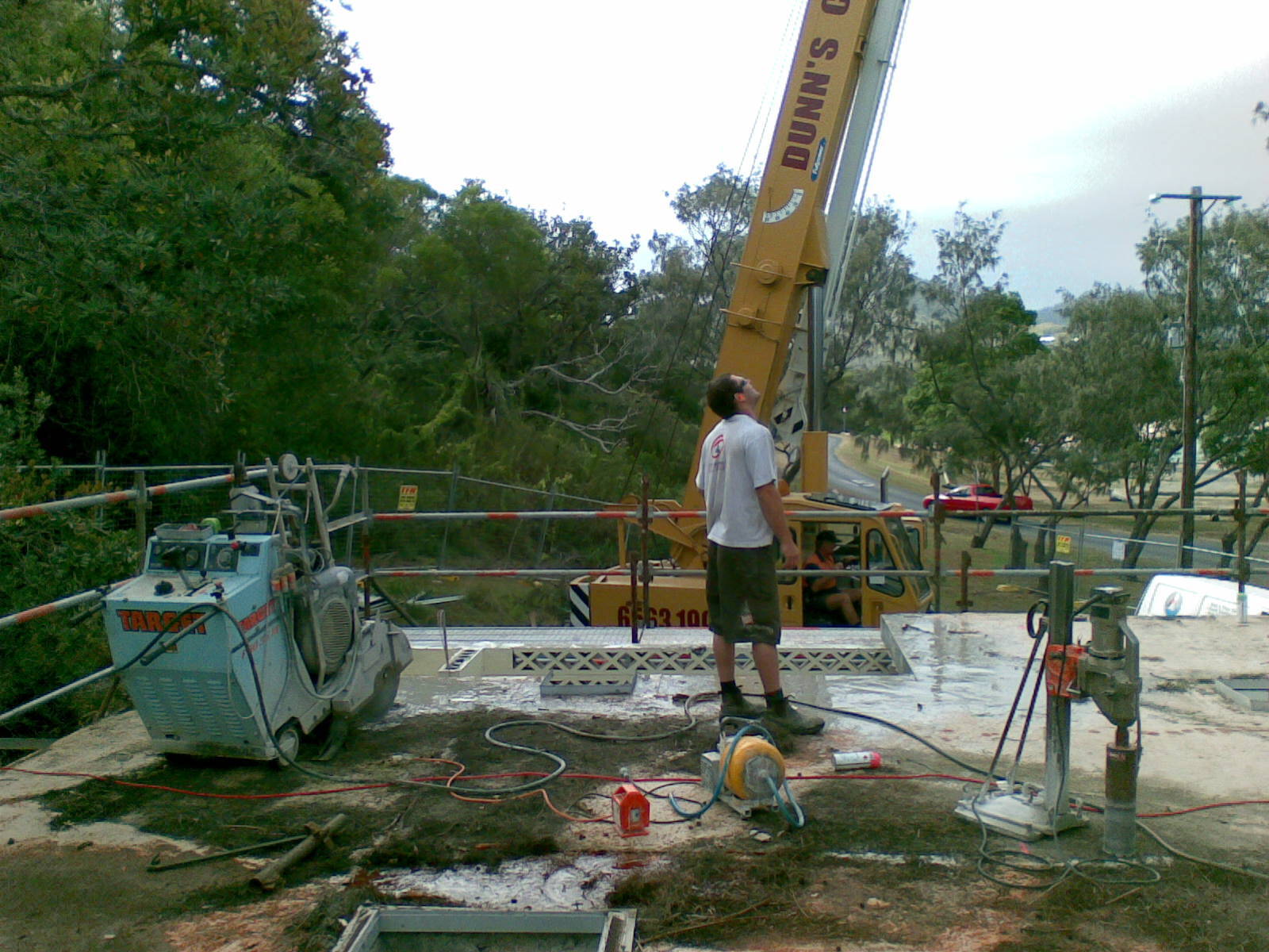 A male Construction Worker Saws Asphalt With A Seam Cutter — Concrete Cutters In Port Macquarie, NSW