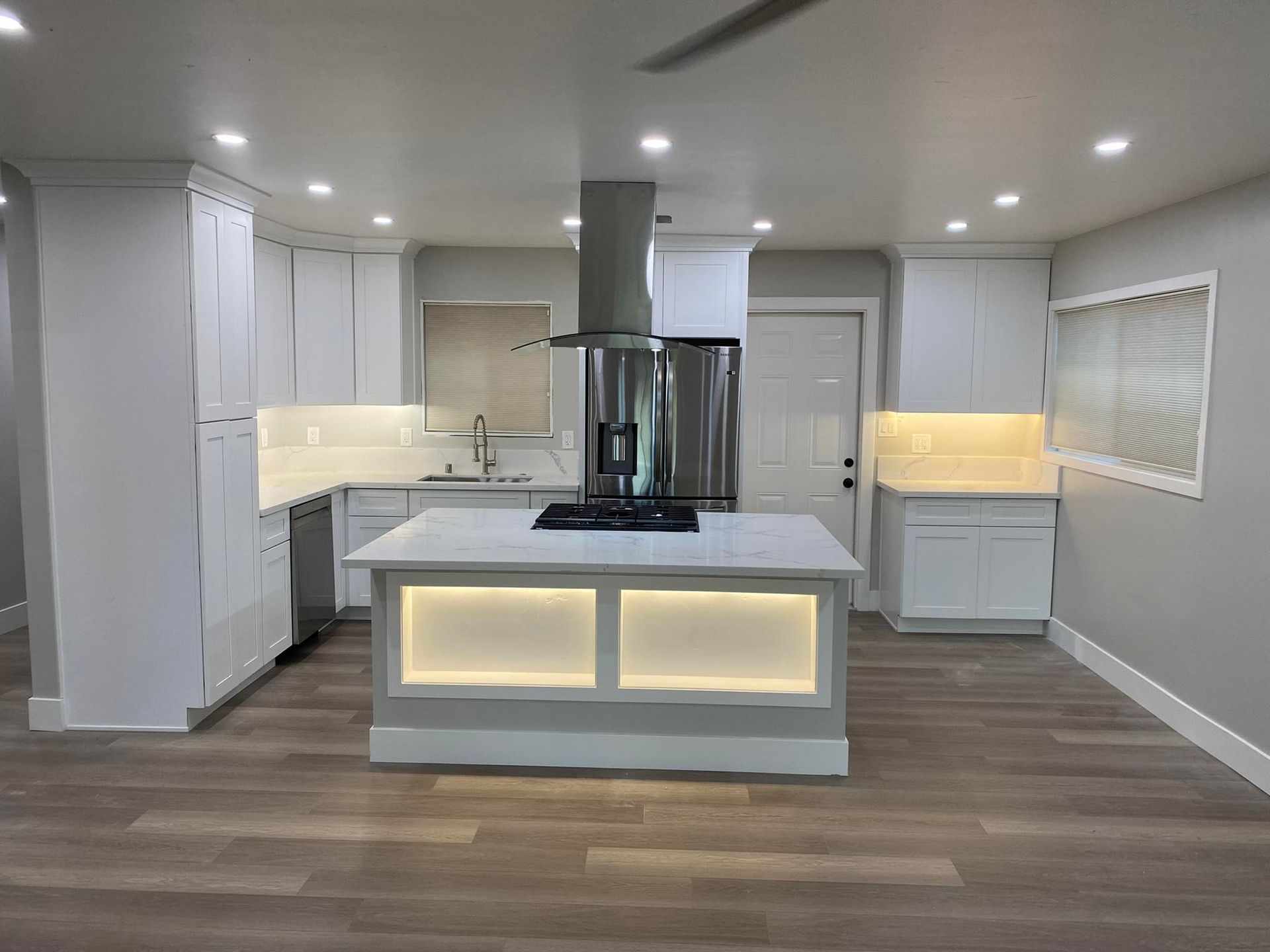 A kitchen with white cabinets and a large island in the middle.