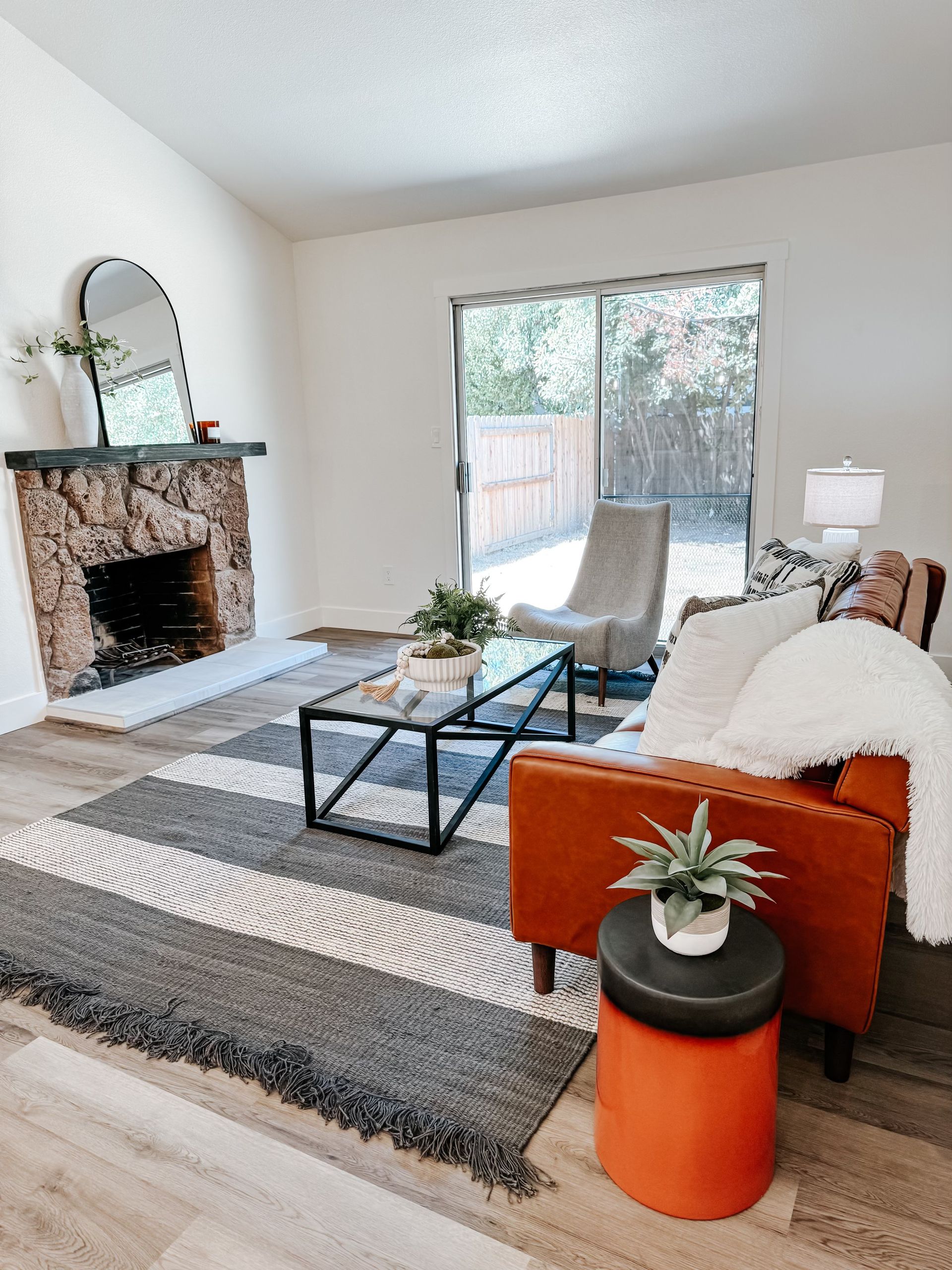 A living room with a couch , chair , coffee table and fireplace.