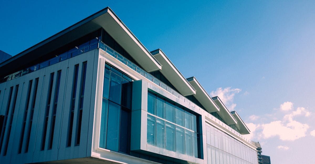 A large building with a lot of windows and a blue sky in the background.