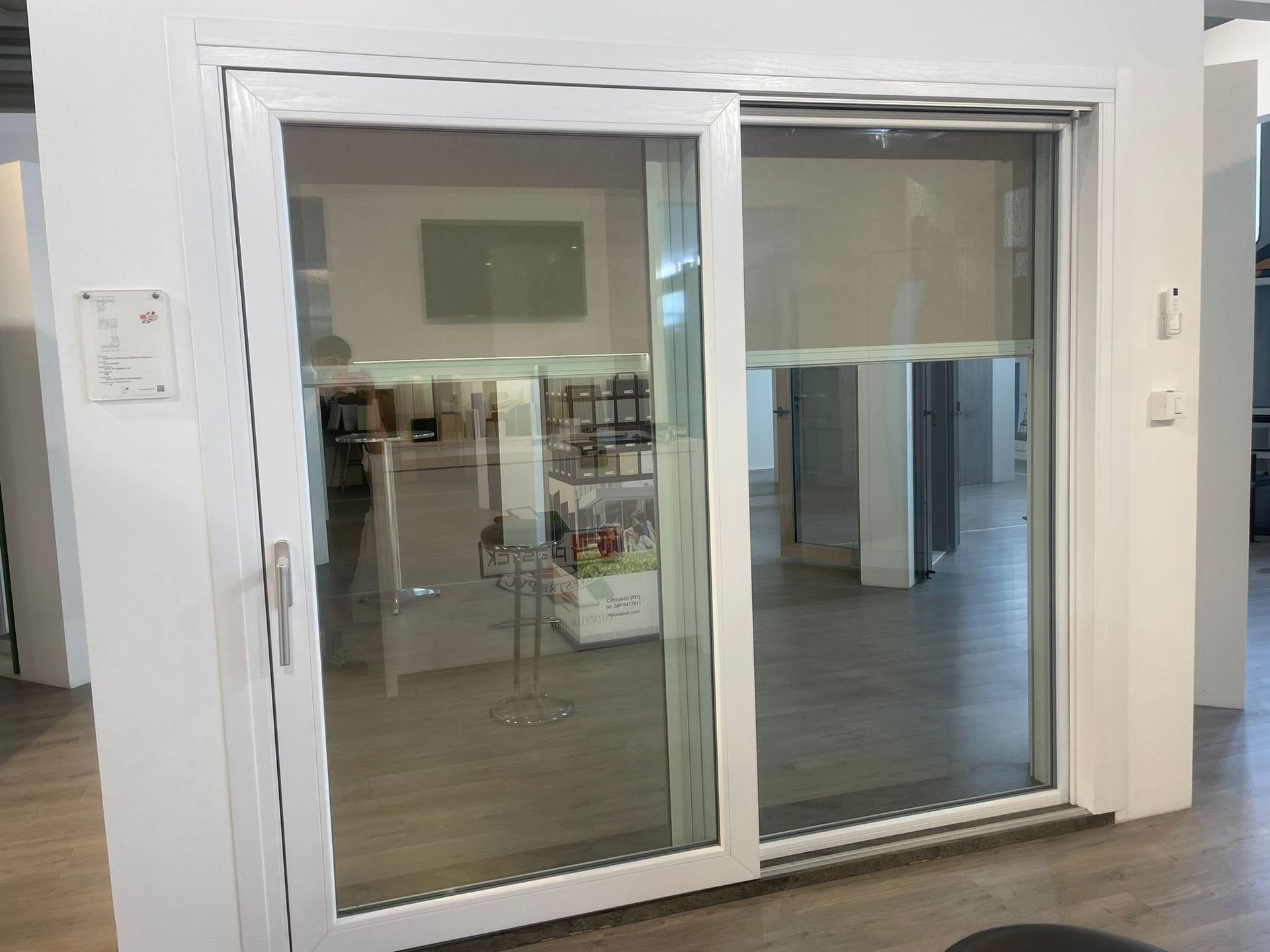 Una porta scorrevole in vetro bianca con persiane in una stanza.