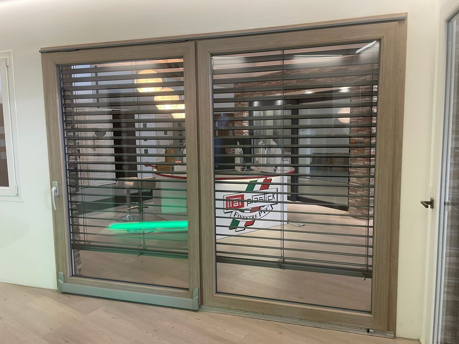 Un paio di porte scorrevoli in vetro con persiane in una stanza.