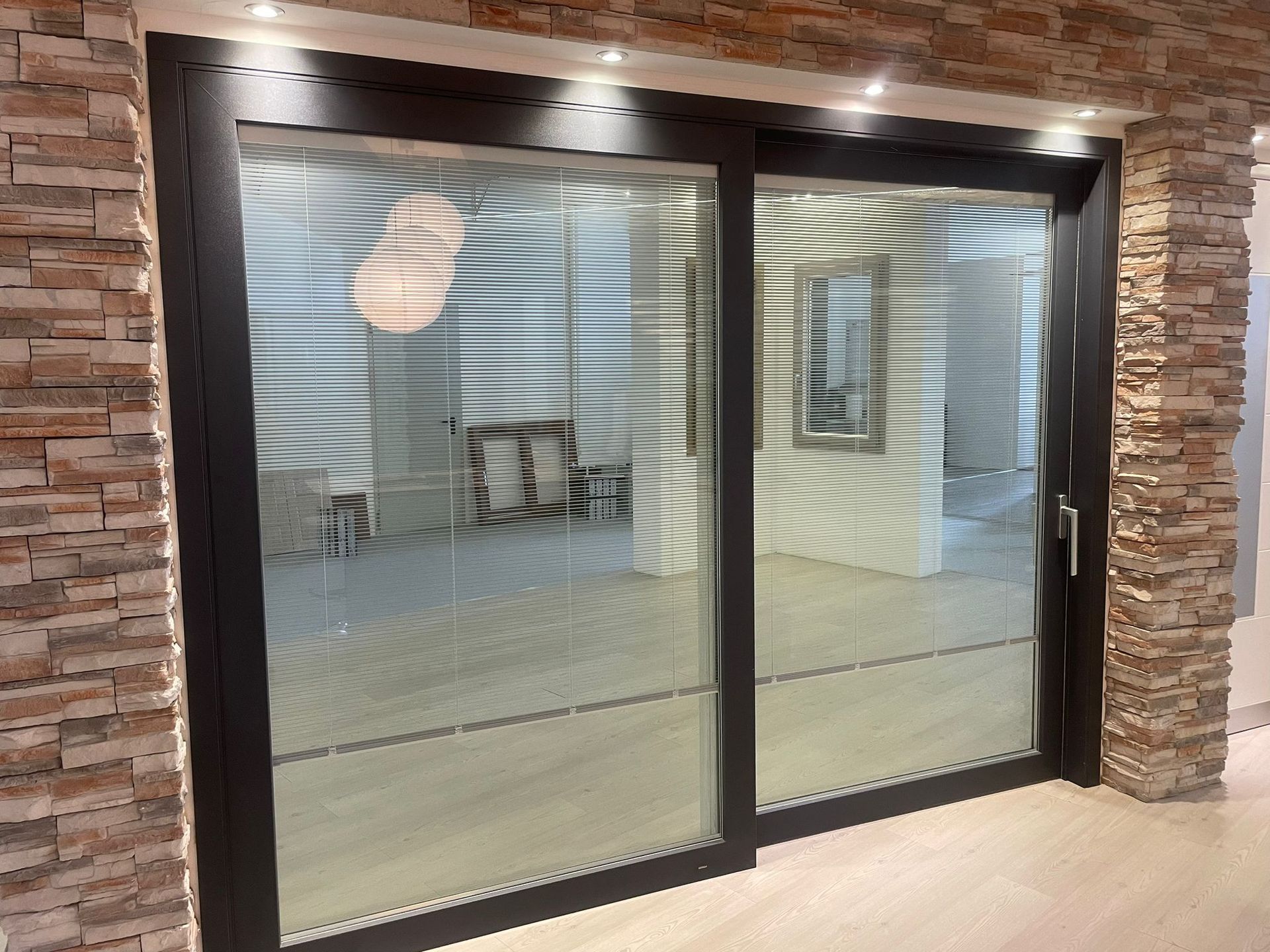 Una porta scorrevole in vetro con le persiane in una stanza