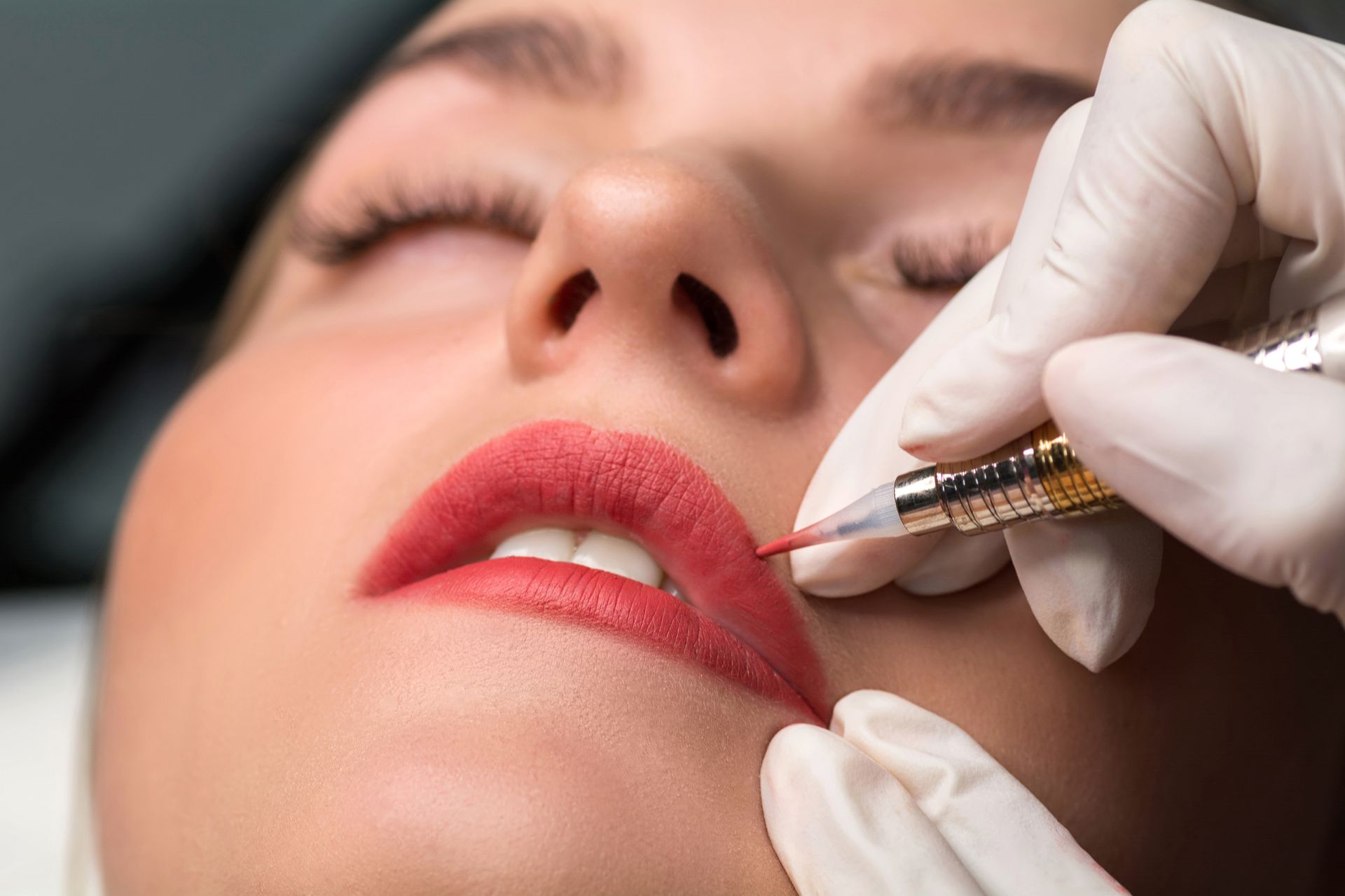 a woman is getting a permanent makeup tattoo on her lips .
