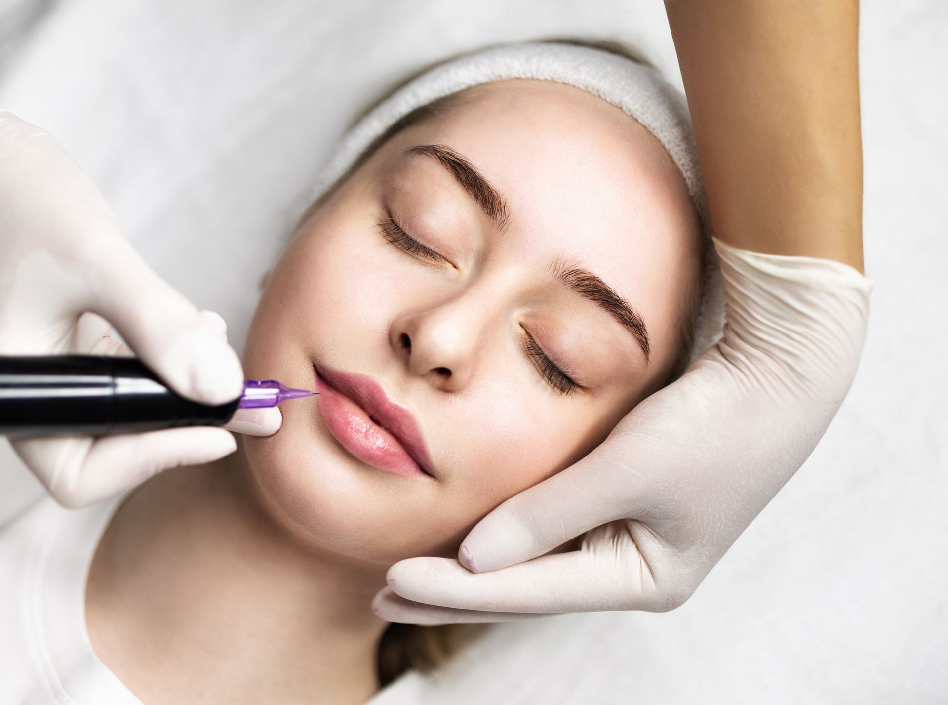 a woman is getting permanent makeup on her lips .