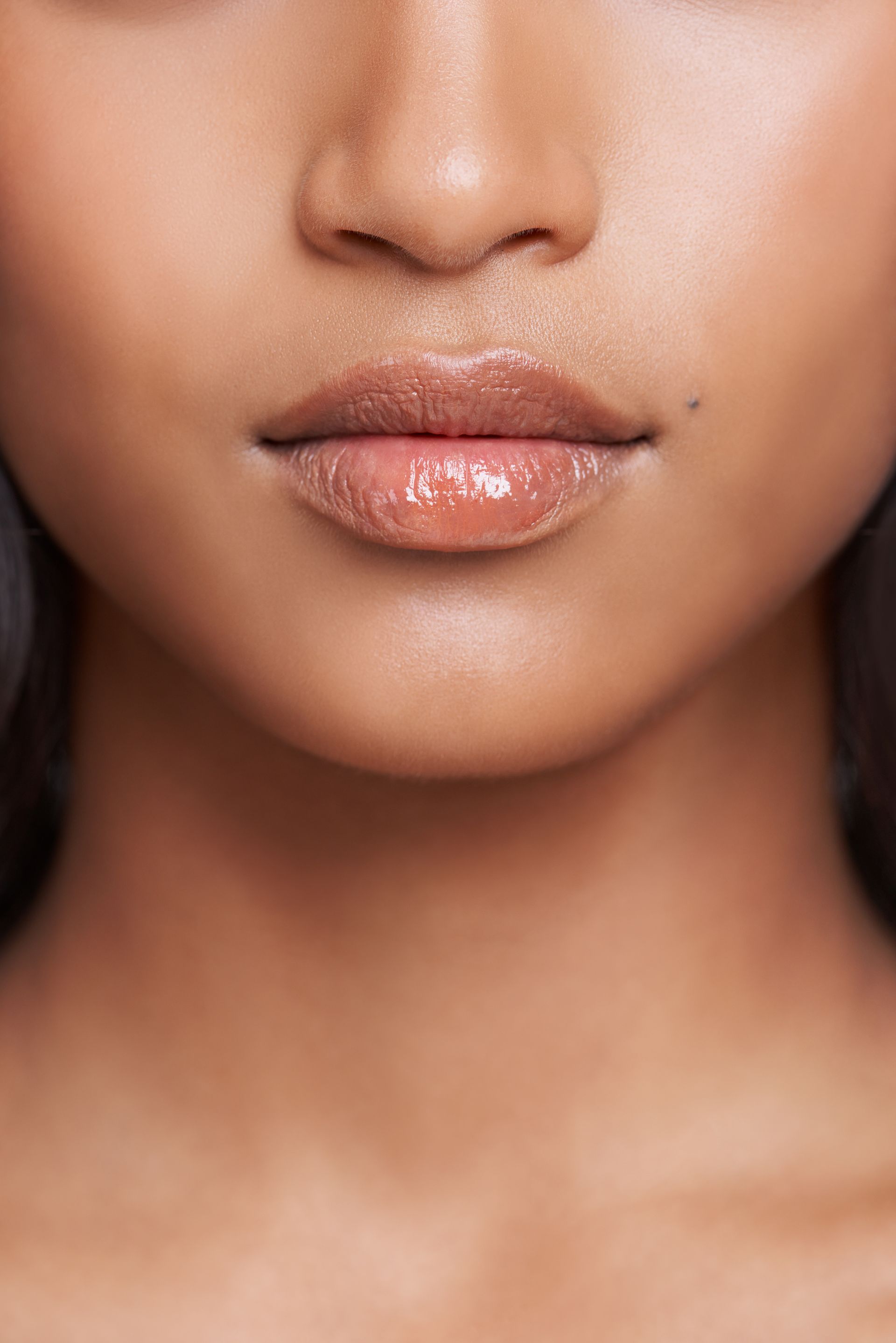 a close up of a woman 's lips with gloss on them .