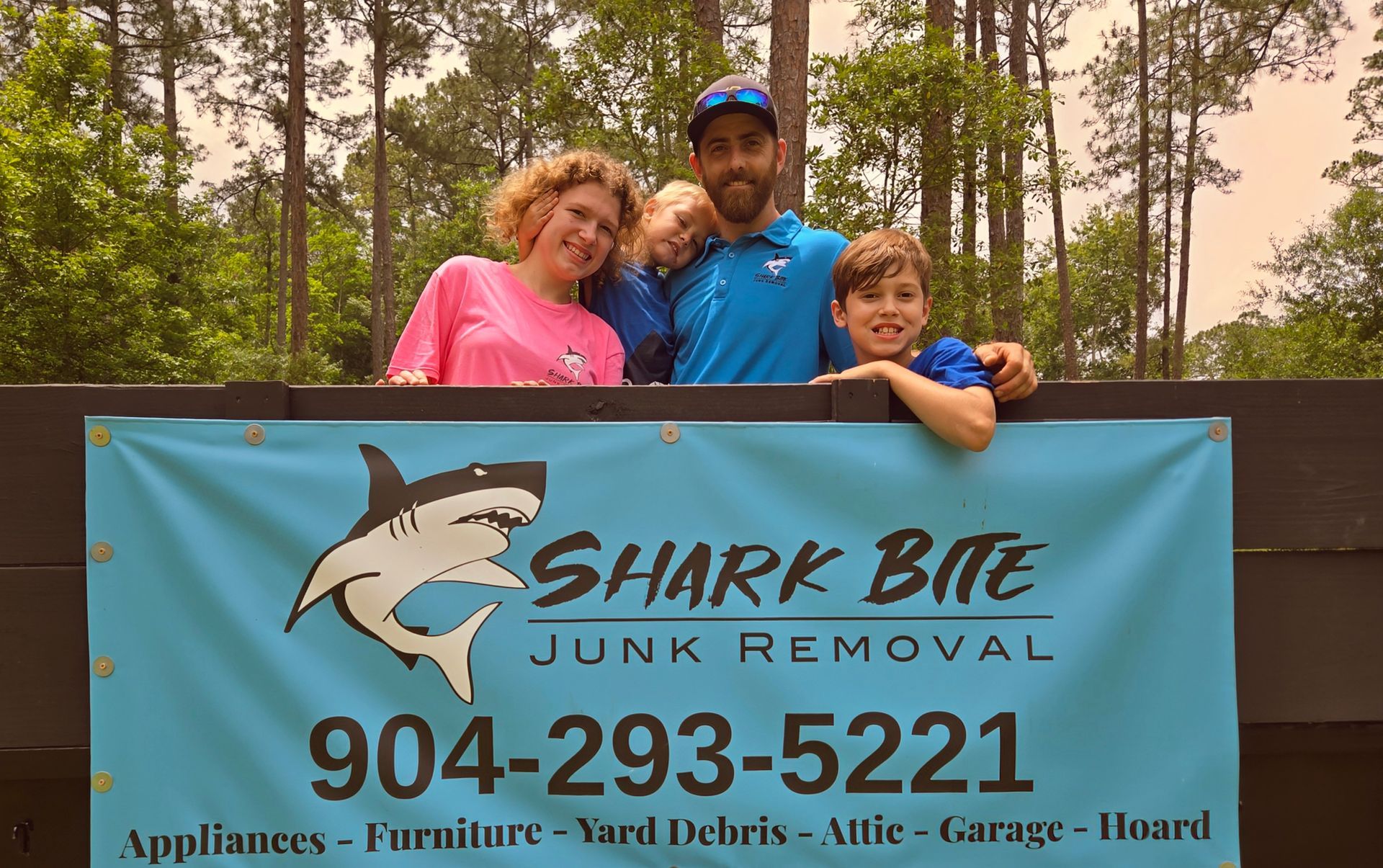 A blue sign for shark bite junk removal with a shark on it