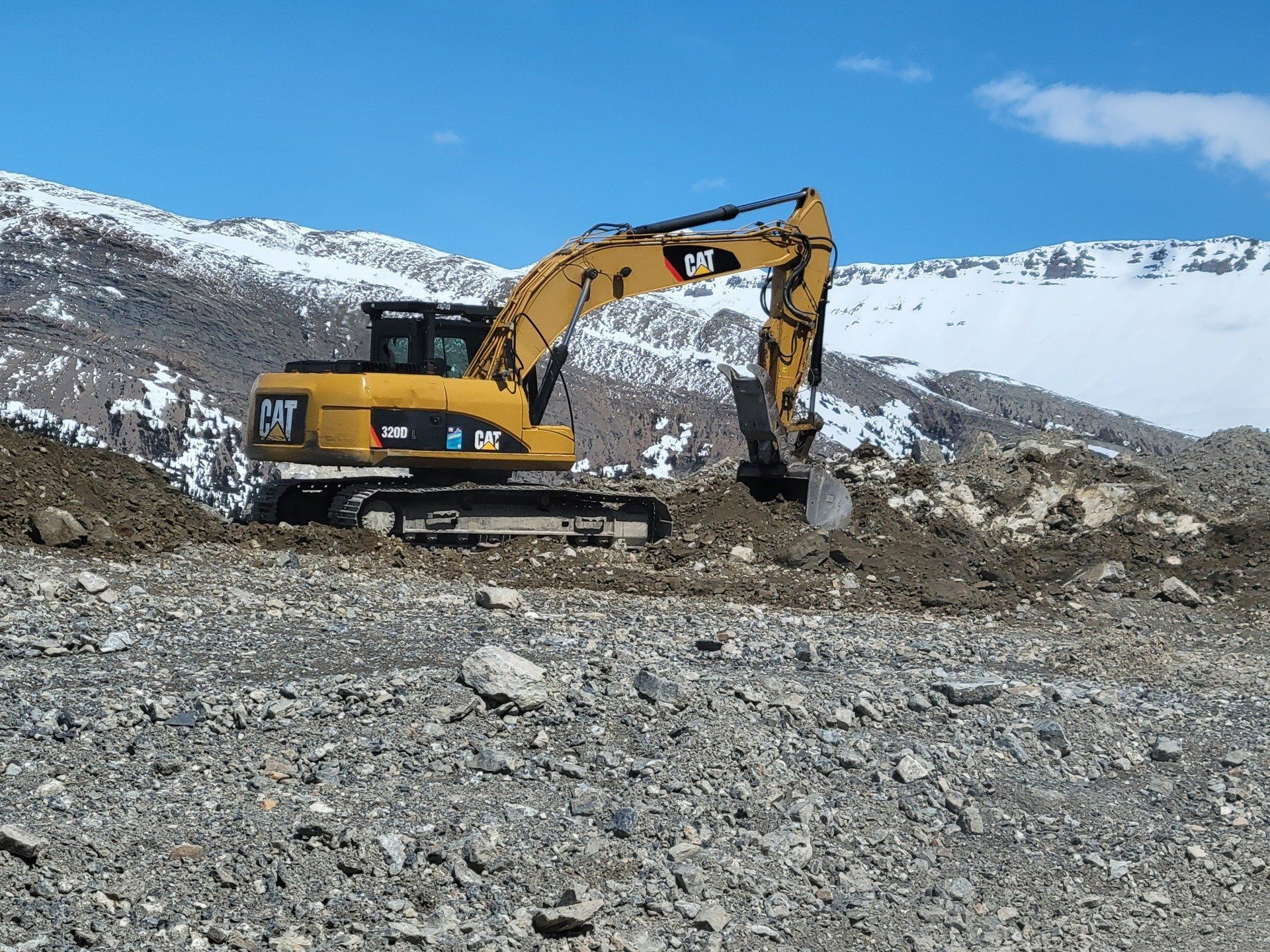 An excavator dumping earth into a pile.