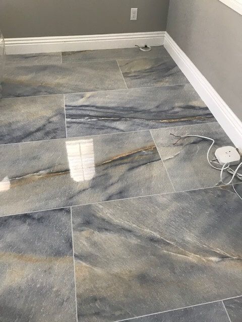 A tiled floor in a room with a lamp on it.