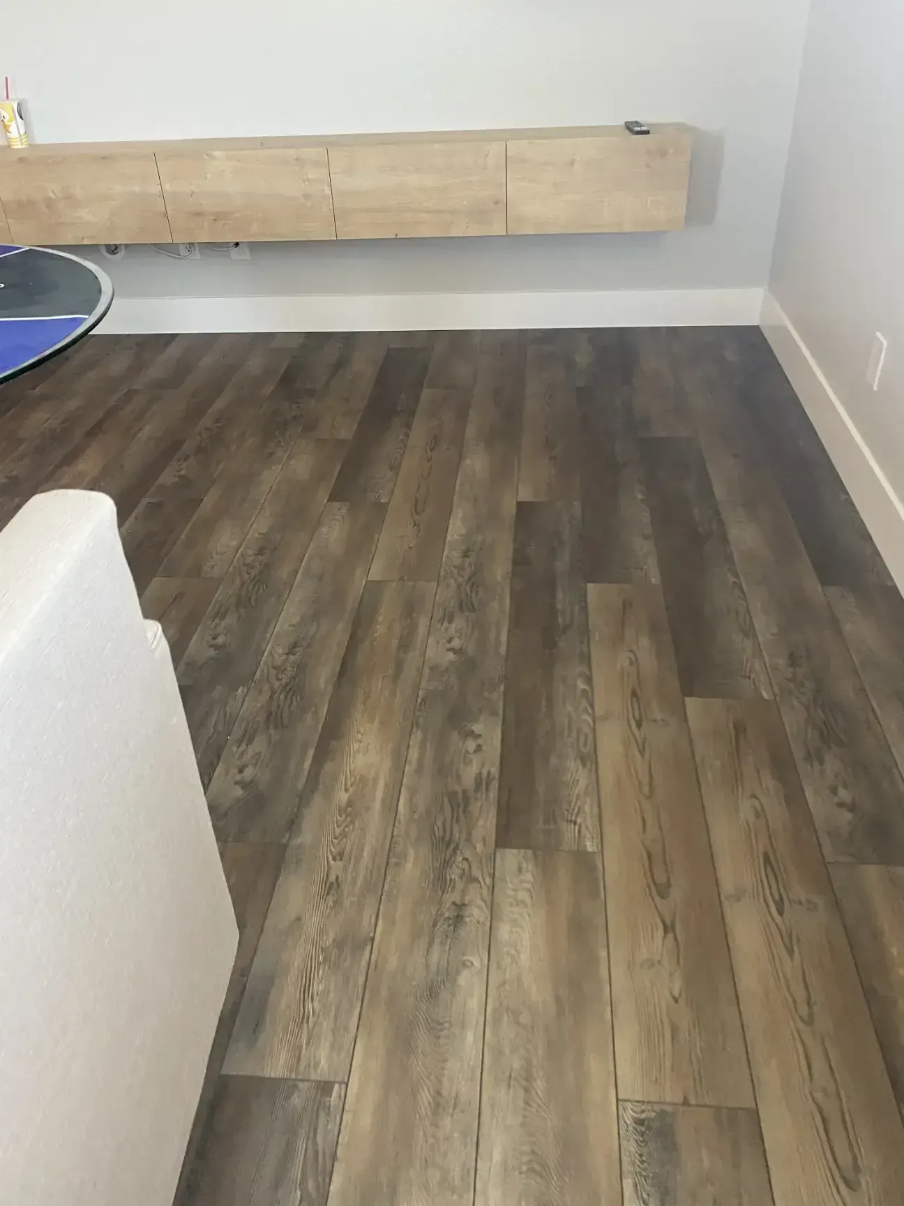 A living room with a wooden floor and a white couch.