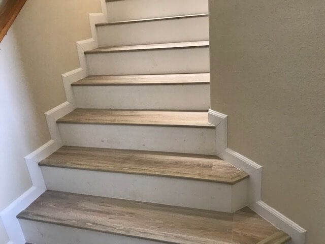 A set of stairs with wooden steps and white walls