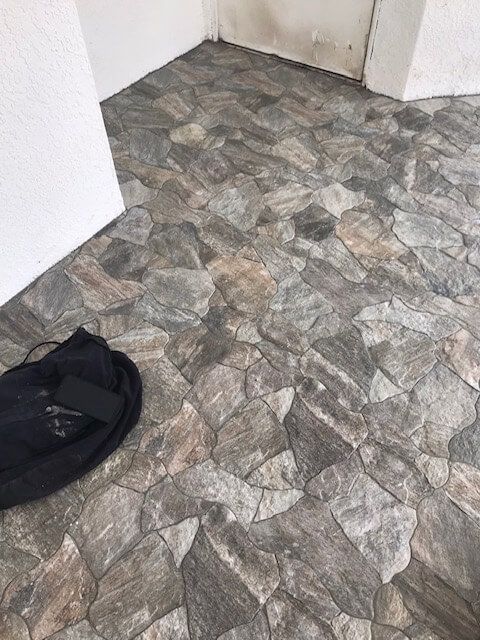 A bag is laying on a stone floor next to a door.