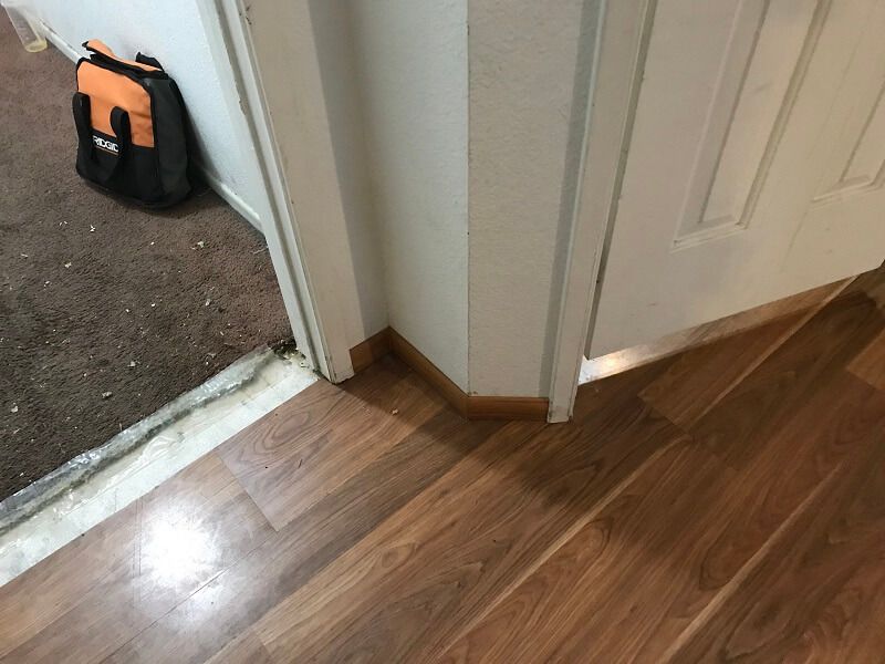 A backpack is sitting on the floor next to a door.