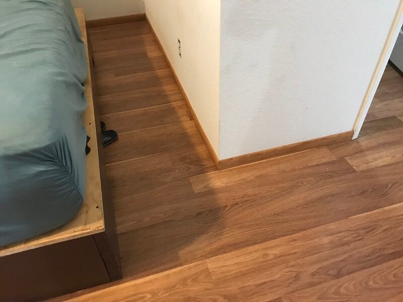 A bed is sitting on top of a wooden platform in a room.