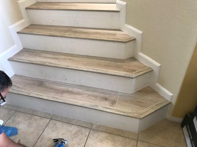 A person is cleaning a set of stairs with a spray bottle.