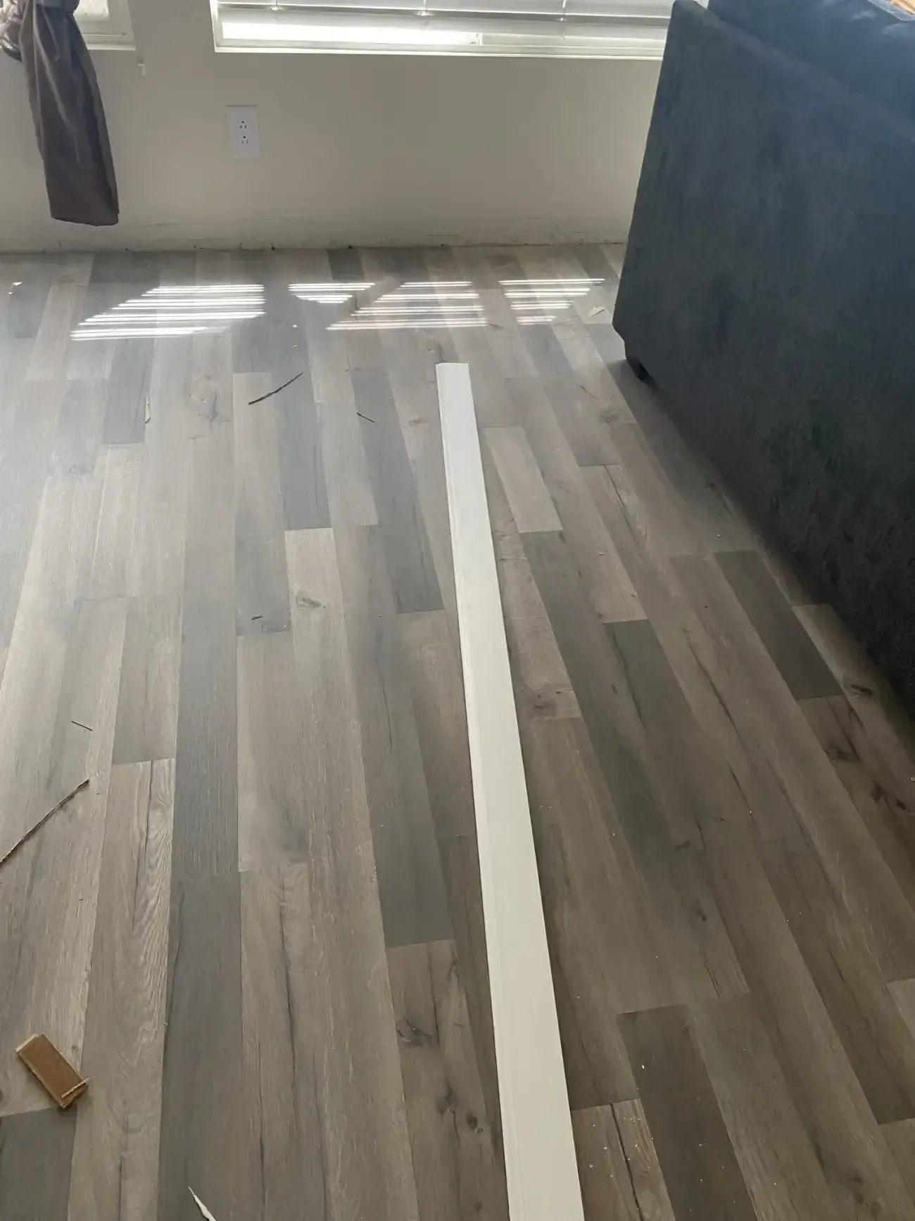 A white line on a wooden floor in a living room.
