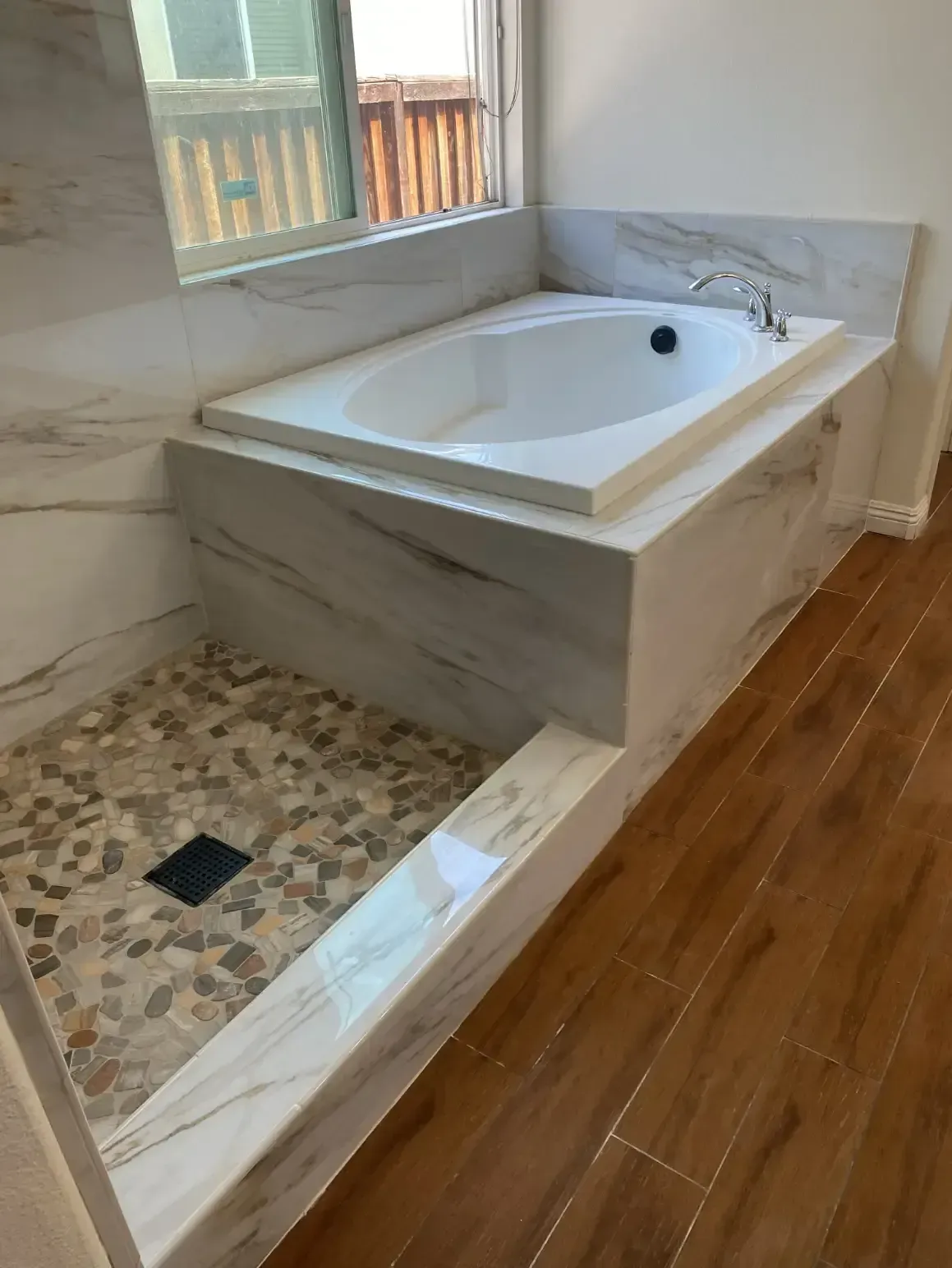 A bathroom with a bathtub and a walk in shower.