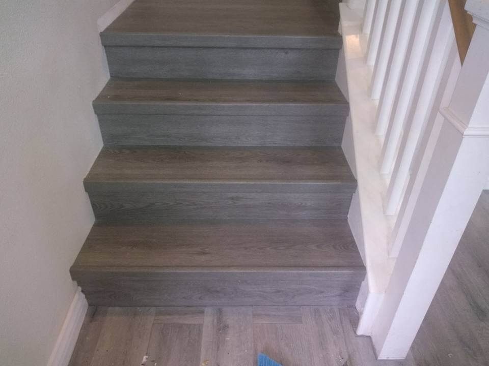 A set of stairs with wooden steps and a white railing.