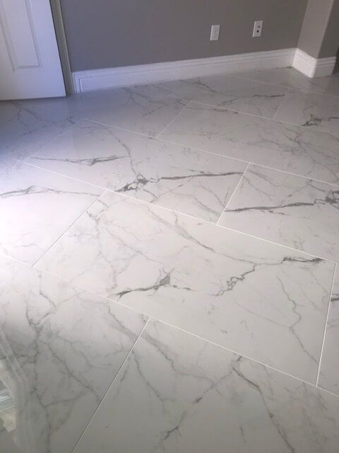 A room with a marble floor and a gray wall.