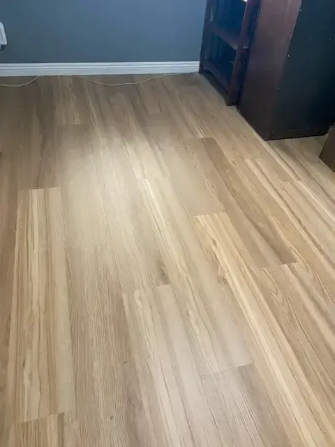 A room with a wooden floor and a bookshelf.