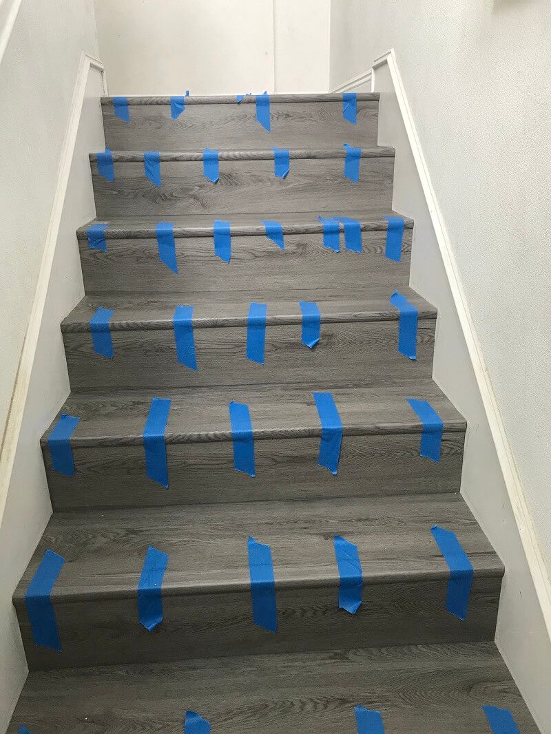 A set of stairs with blue tape on them.