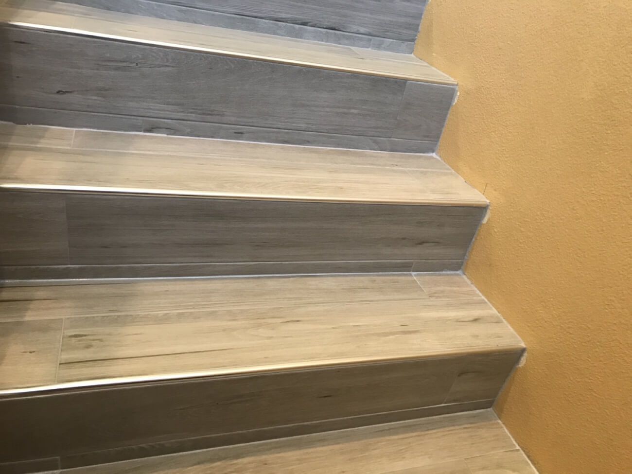 A close up of a set of stairs with a wooden floor.