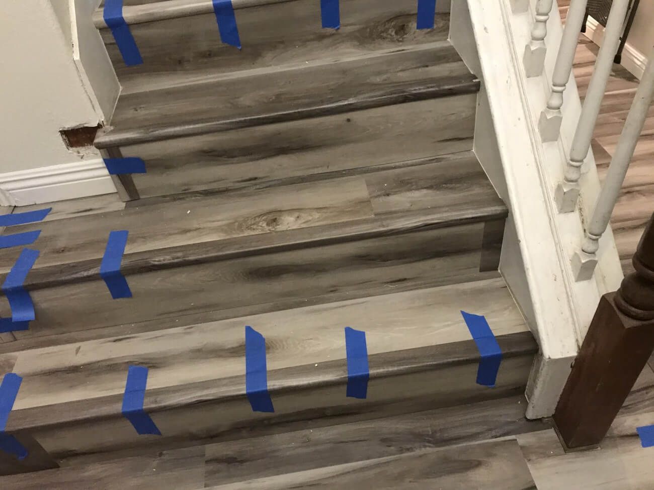 A set of wooden stairs with blue tape on them.