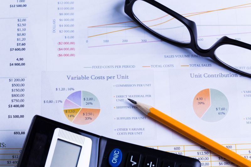 Photo of glasses and a calculator on top of financial reports | Featured image for the Business Services page for Rudd Mantell Accountants