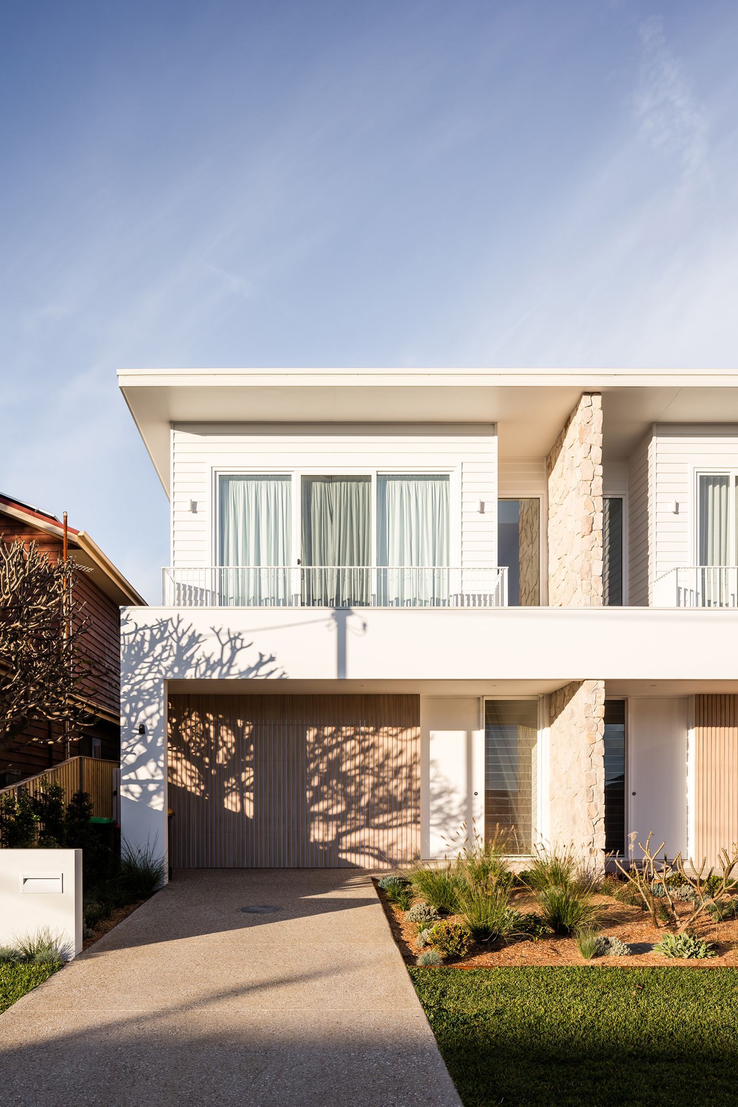 A large white house with a lot of windows and a walkway leading to it.